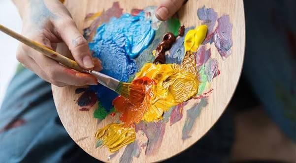 Une palette de peinture avec des couleurs et un pinceau.