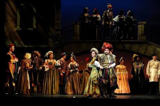 Des acteurs en costume jouent une pièce de théâtre sur scène.